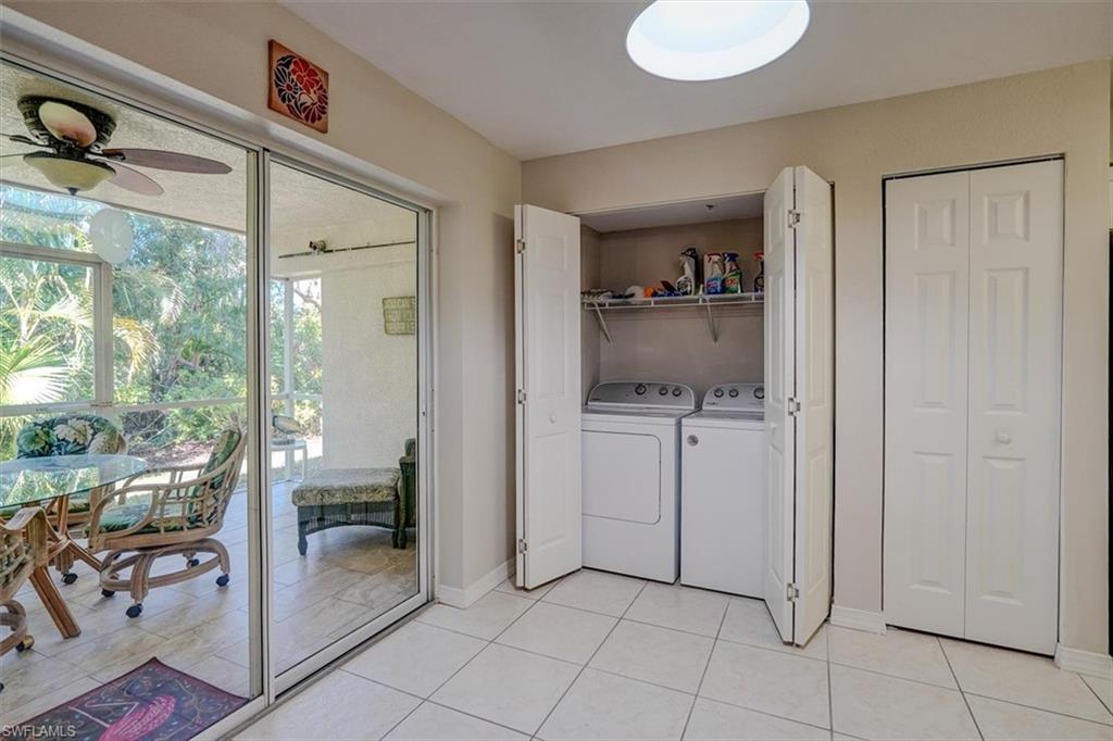 Laundry area with light tile patterned floors, separate washer and dryer, and a ceiling fan