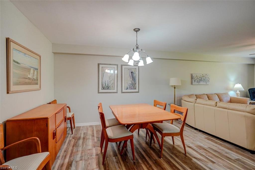 Dining room with wood finished floors and a chandelier
