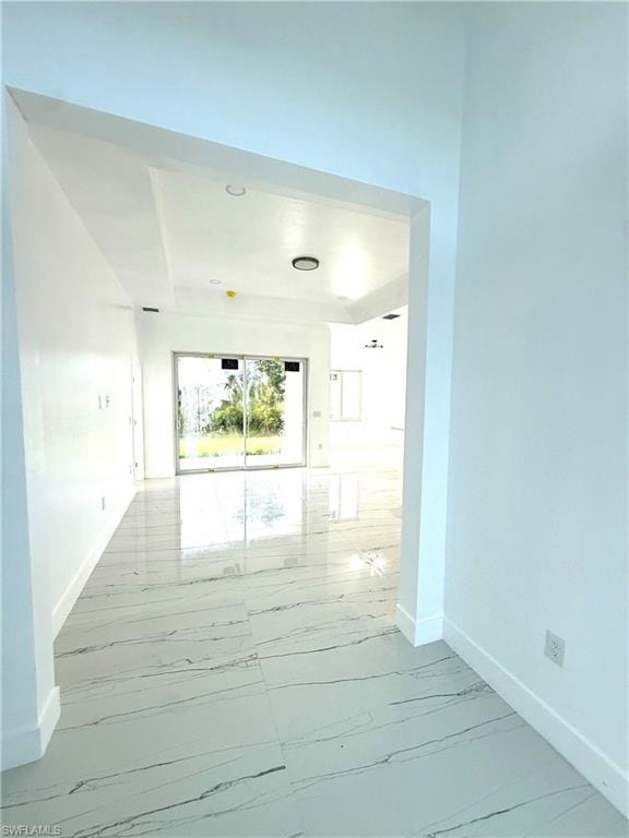 Unfurnished room featuring light marble finish floors and baseboards