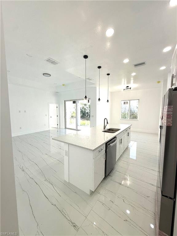 Kitchen with open floor plan, white cabinets, light marble finish floors, and recessed lighting