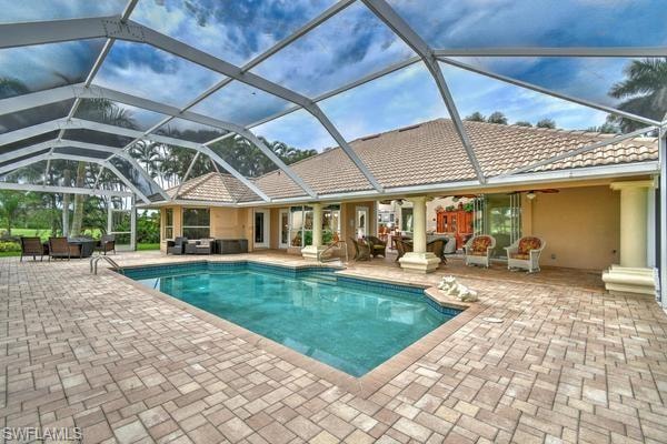 Swimming pool with outdoor lounge area, a patio area, a lanai, and a sunroom