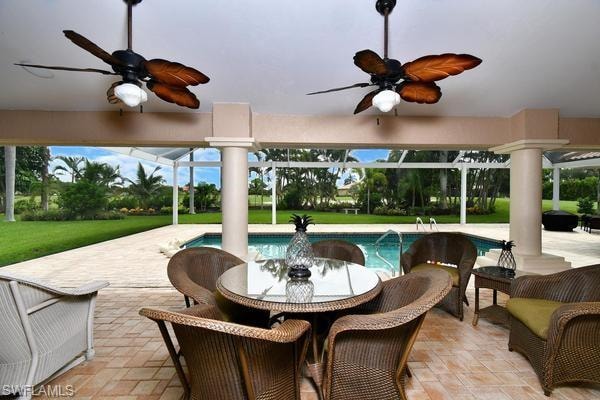 View of patio featuring a ceiling fan, a lanai, an outdoor pool, and outdoor dining area