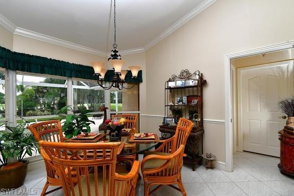 Dining area featuring light tile patterned floors, ornamental molding, and a chandelier