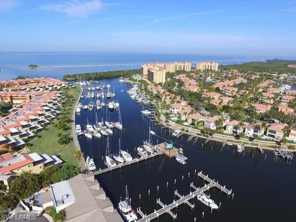 Aerial view of property and surrounding area with a large body of water and numerous boat docks
