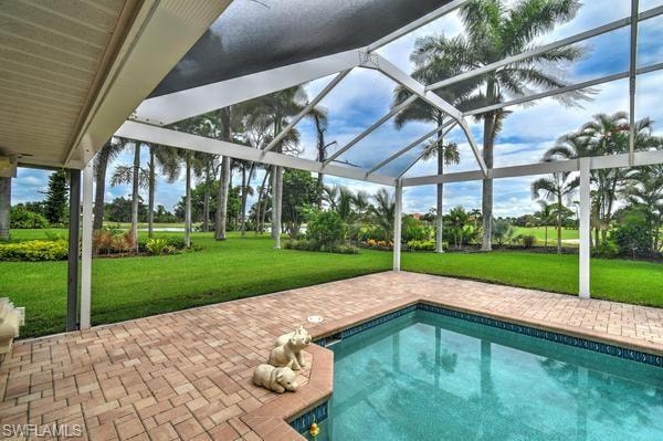 Outdoor pool with a patio, a lawn, glass enclosure, and a sunroom