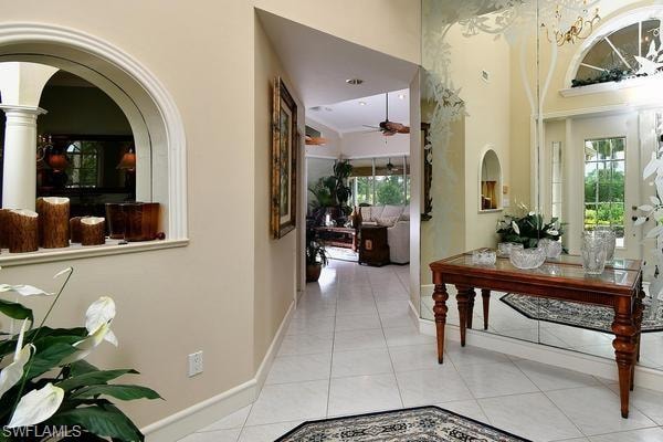 Hallway featuring light tile patterned floors and arched walkways