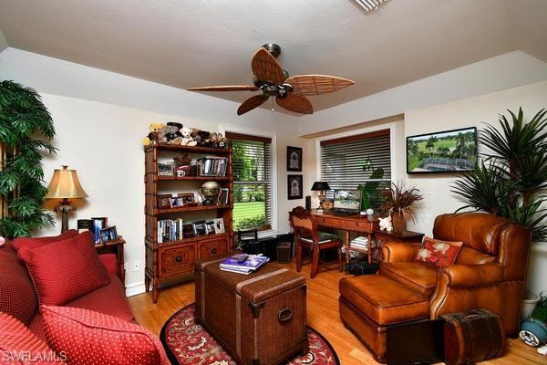 Office area with light wood-style flooring and ceiling fan
