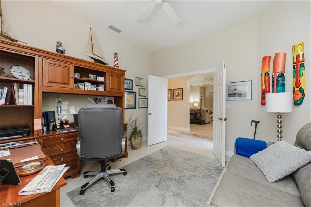 Home office with light tile patterned flooring and ceiling fan