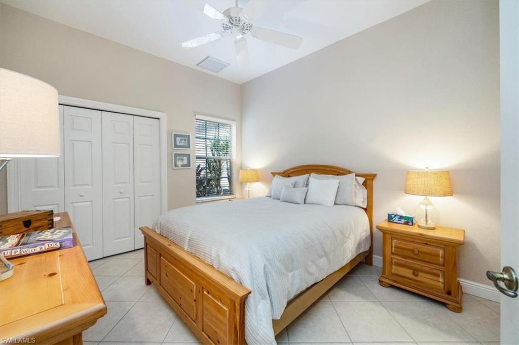 Bedroom with light tile patterned flooring, a closet, and ceiling fan
