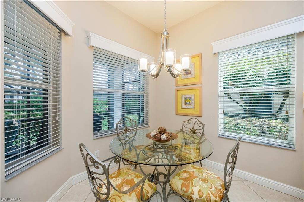 Dining room with light tile patterned floors and a chandelier