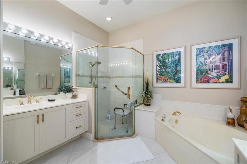 Full bathroom featuring vanity, a garden tub, a stall shower, light tile patterned floors, and recessed lighting