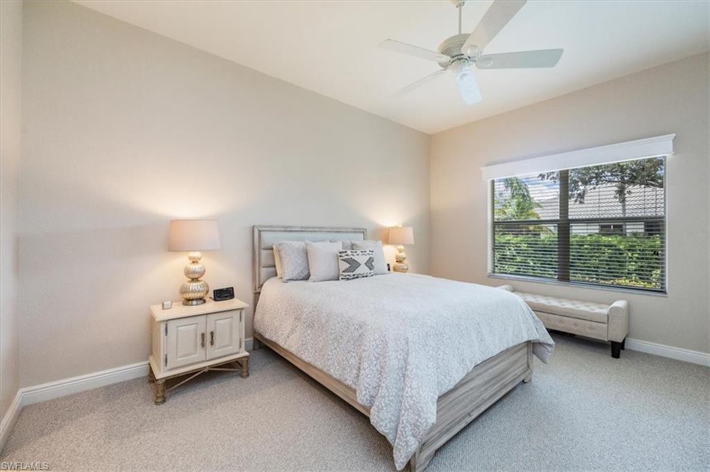 Bedroom with light colored carpet and a ceiling fan