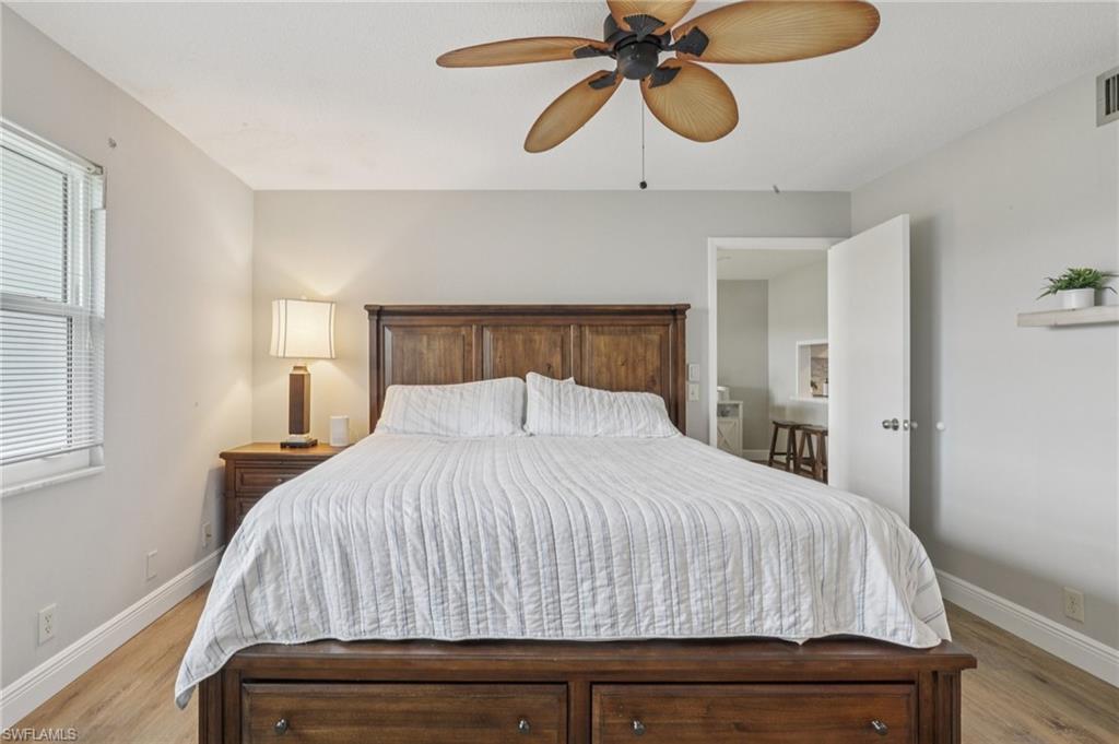 Bedroom featuring ensuite, light LVP floors and ceiling fan