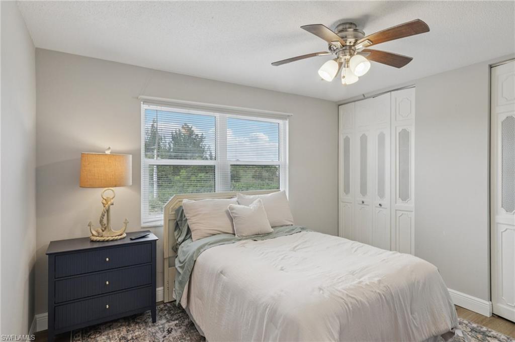 Bedroom featuring ceiling fan, two closets, LVP floors,