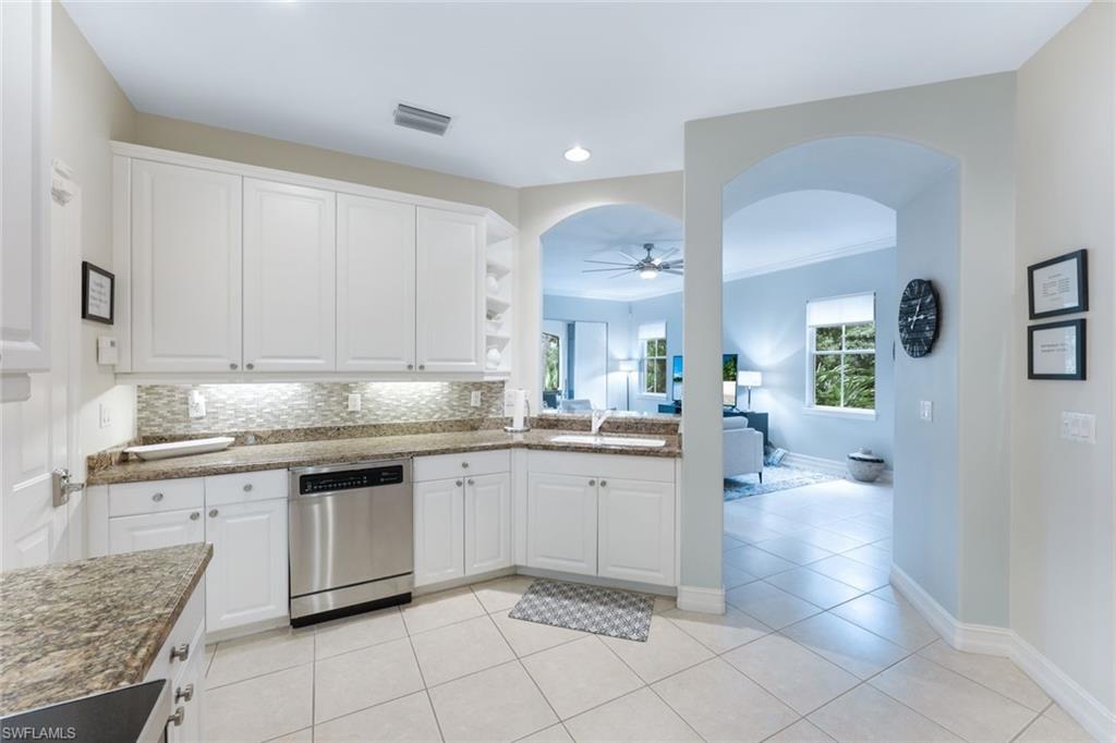 Kitchen featuring dishwasher, sink, white cabinetry, decorative backsplash, and ceiling fan