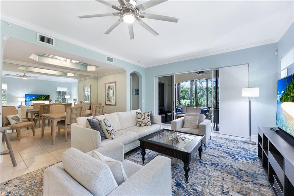 Living room with tile patterned flooring and crown molding