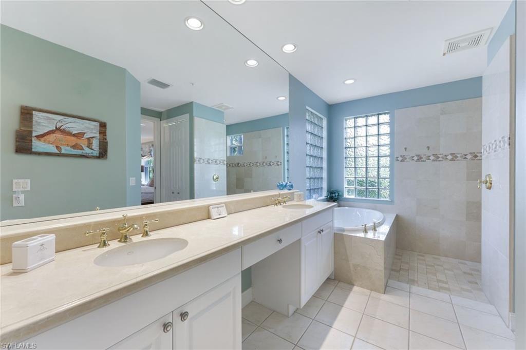 Bathroom with independent shower and bath, vanity, and tile patterned floors