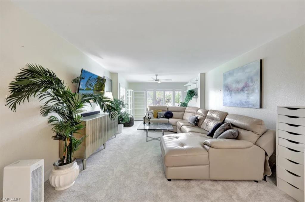 Living area featuring carpet flooring and ceiling fan