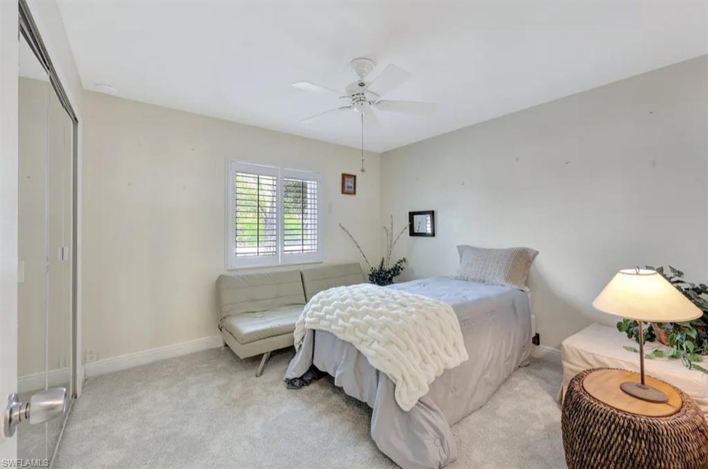 Bedroom with a closet, carpet, and ceiling fan