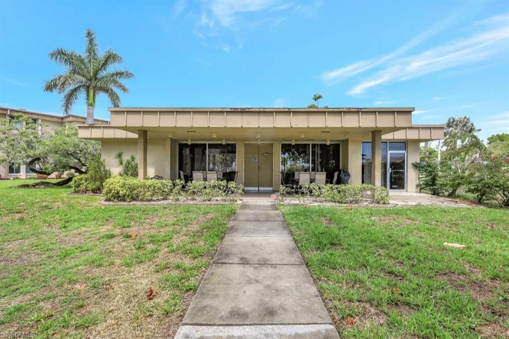 Back of property with a lawn, stucco siding, and a patio
