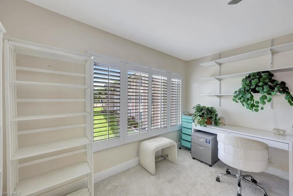 Office area featuring baseboards and light carpet