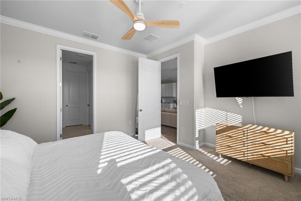 Bedroom featuring crown molding, carpet floors, and a ceiling fan