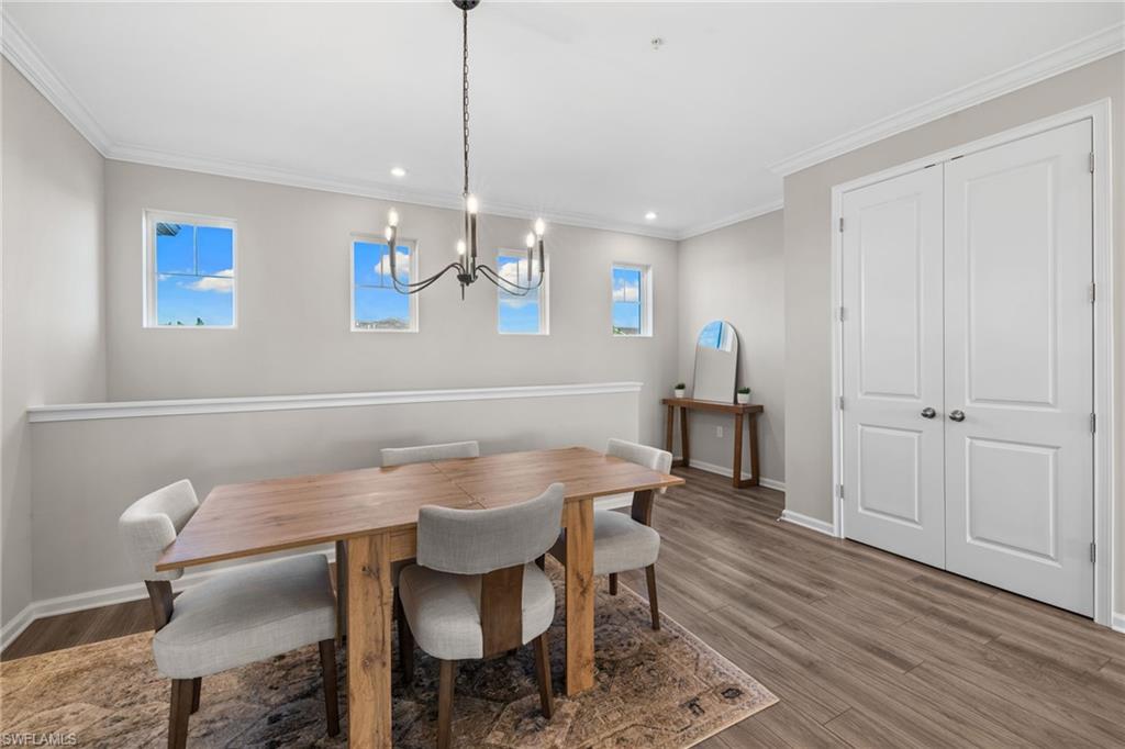 Dining space with crown molding, dark wood-style flooring, a chandelier, and recessed lighting