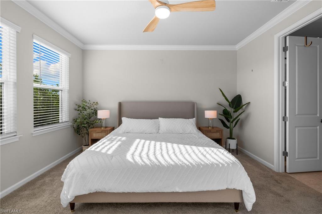 Carpeted bedroom with crown molding and a ceiling fan