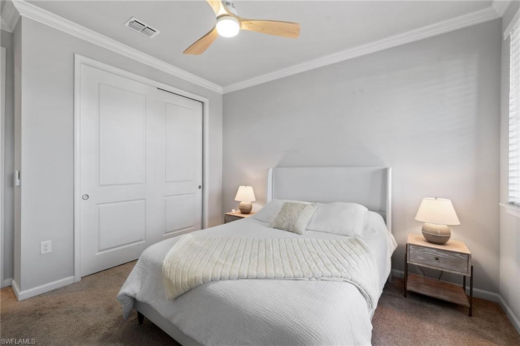Bedroom featuring ornamental molding, carpet flooring, a closet, and a ceiling fan