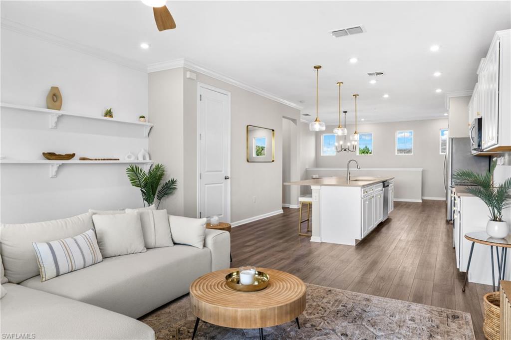 Living area with recessed lighting, dark wood-style floors, and crown molding