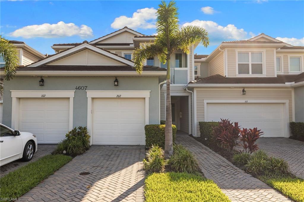 Traditional-style house featuring stucco siding and decorative driveway