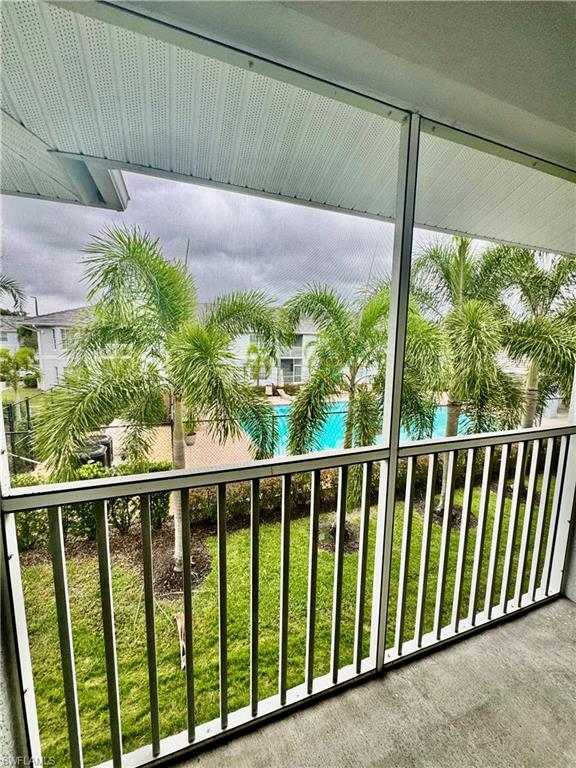Balcony featuring view of pool and a sunroom