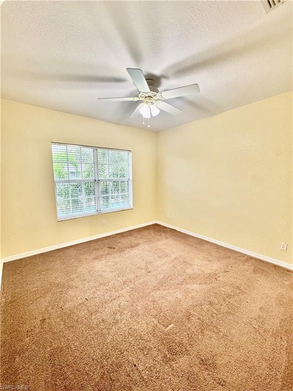 Carpeted spare room featuring a textured ceiling