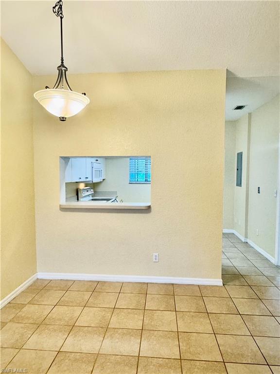 Spare room with light tile patterned floors and baseboards