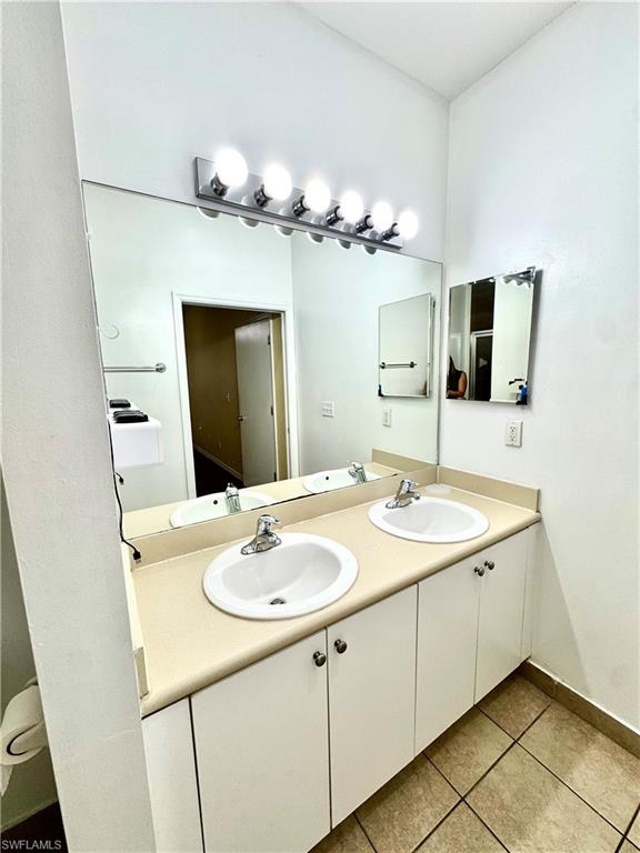 Bathroom featuring double vanity and light tile patterned flooring