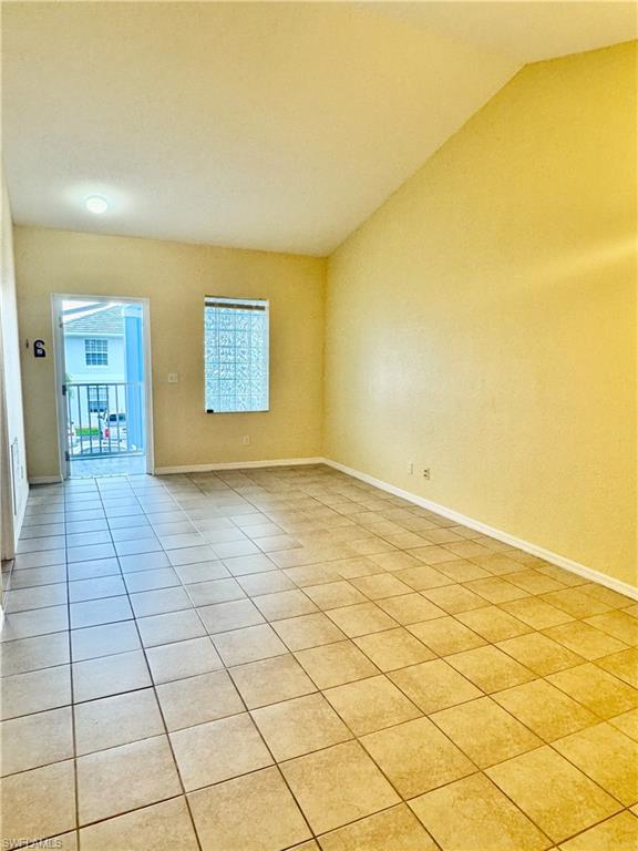 Spare room with tile patterned flooring and lofted ceiling