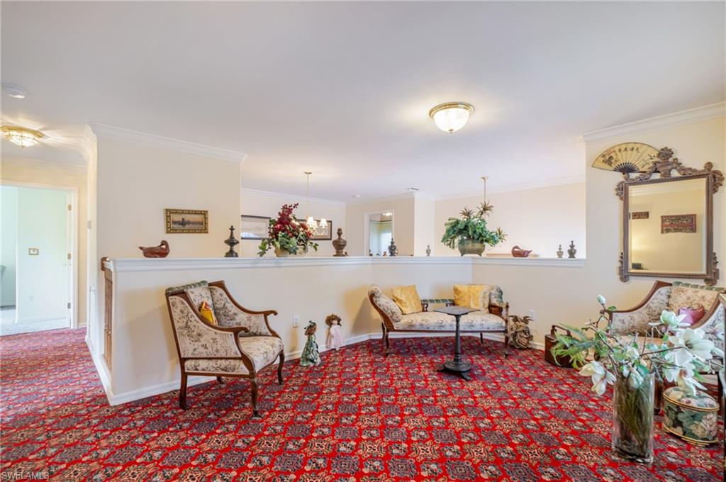 Sitting room with crown molding and carpet flooring