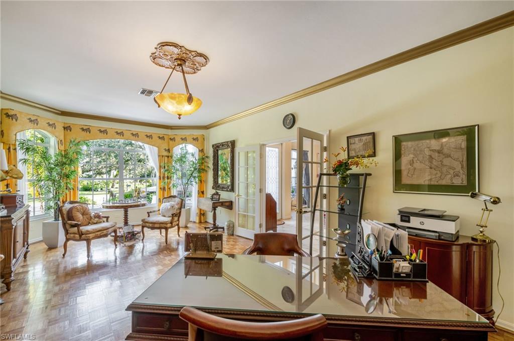 Home office with ornamental molding, french doors, and plenty of natural light
