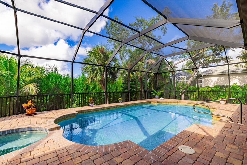 Outdoor pool with a lanai, an in-ground hot tub, a sunroom, and a patio area