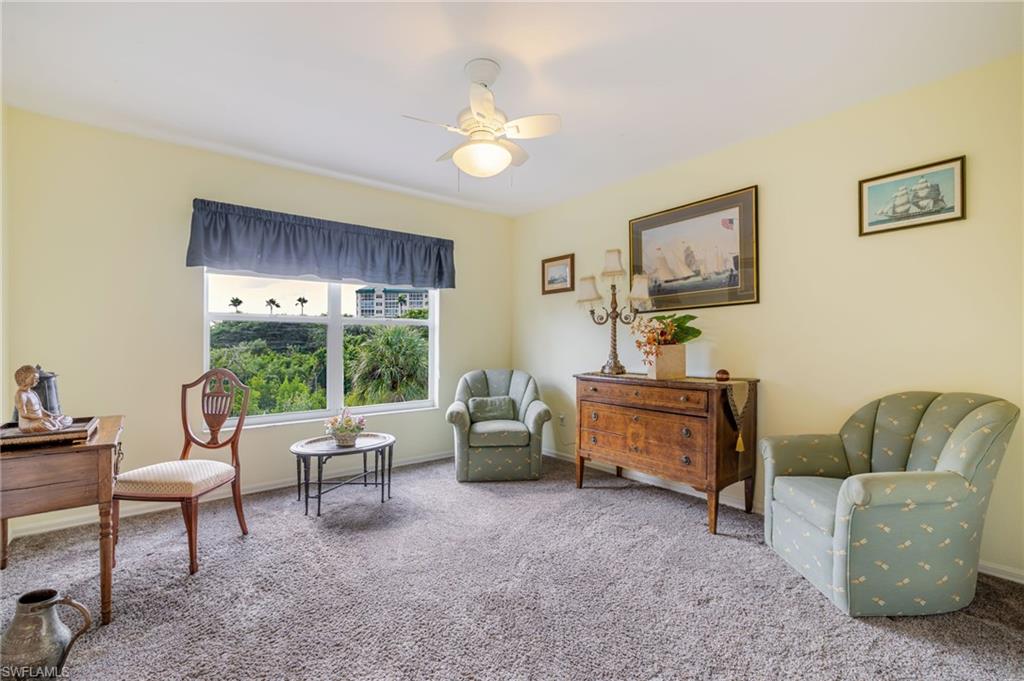 Living area featuring carpet flooring and a ceiling fan