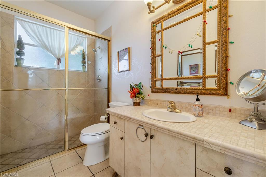 Full bathroom featuring vanity, a stall shower, and light tile patterned floors