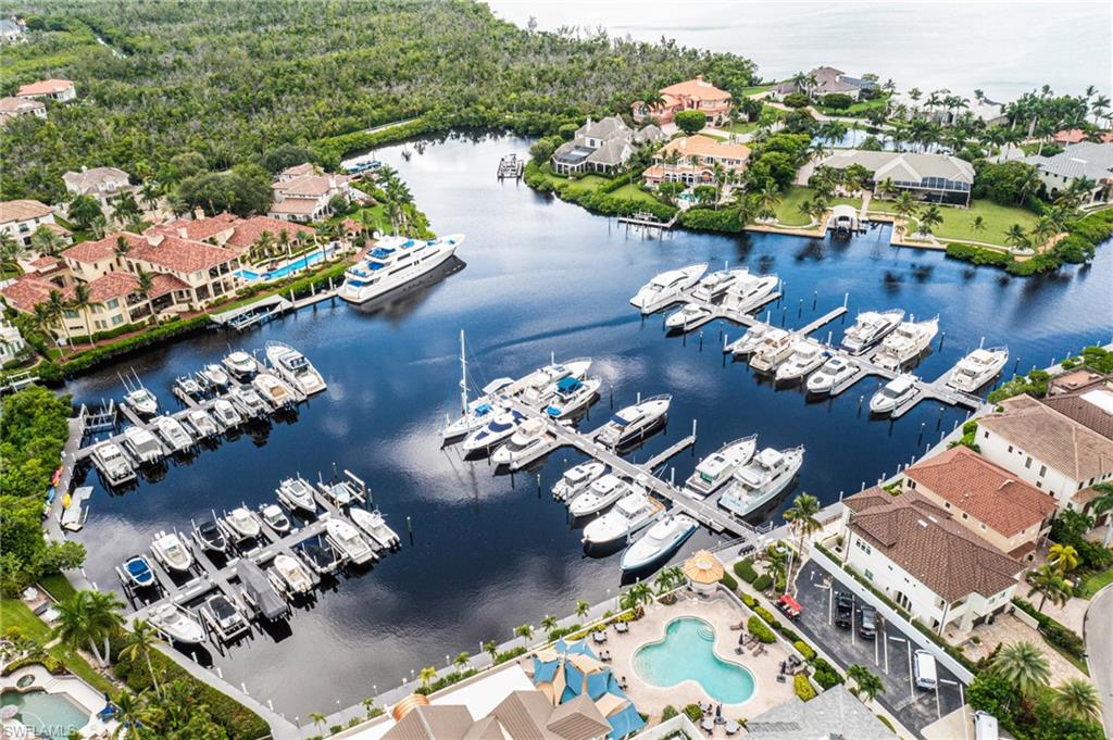Aerial perspective of suburban area featuring a nearby body of water and a pool area