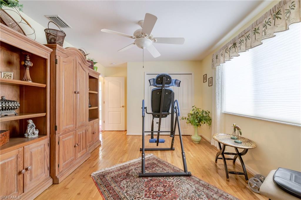 Exercise room featuring light wood finished floors and ceiling fan