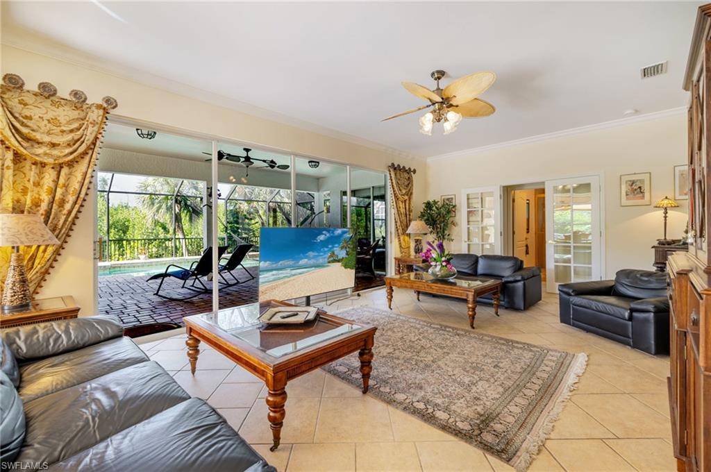 Living room featuring ornamental molding, plenty of natural light, light tile patterned floors, and a sunroom