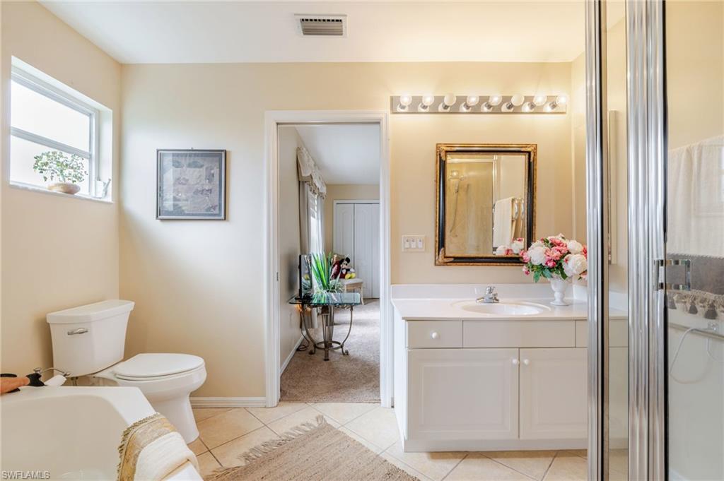 Bathroom featuring vanity, light tile patterned flooring, a bath, and a shower stall