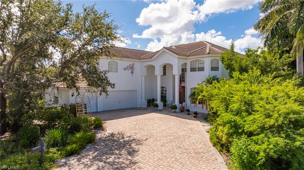 Mediterranean / spanish home with a tiled roof, stucco siding, decorative driveway, and a garage