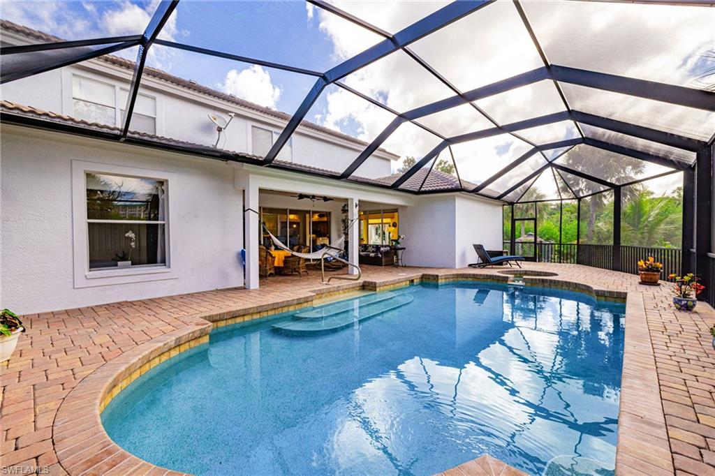 Outdoor pool featuring a patio area, glass enclosure, a sunroom, and a ceiling fan
