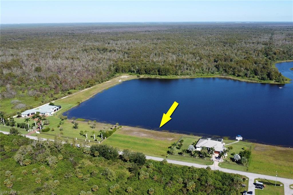 View of property location with a heavily wooded area and a nearby body of water