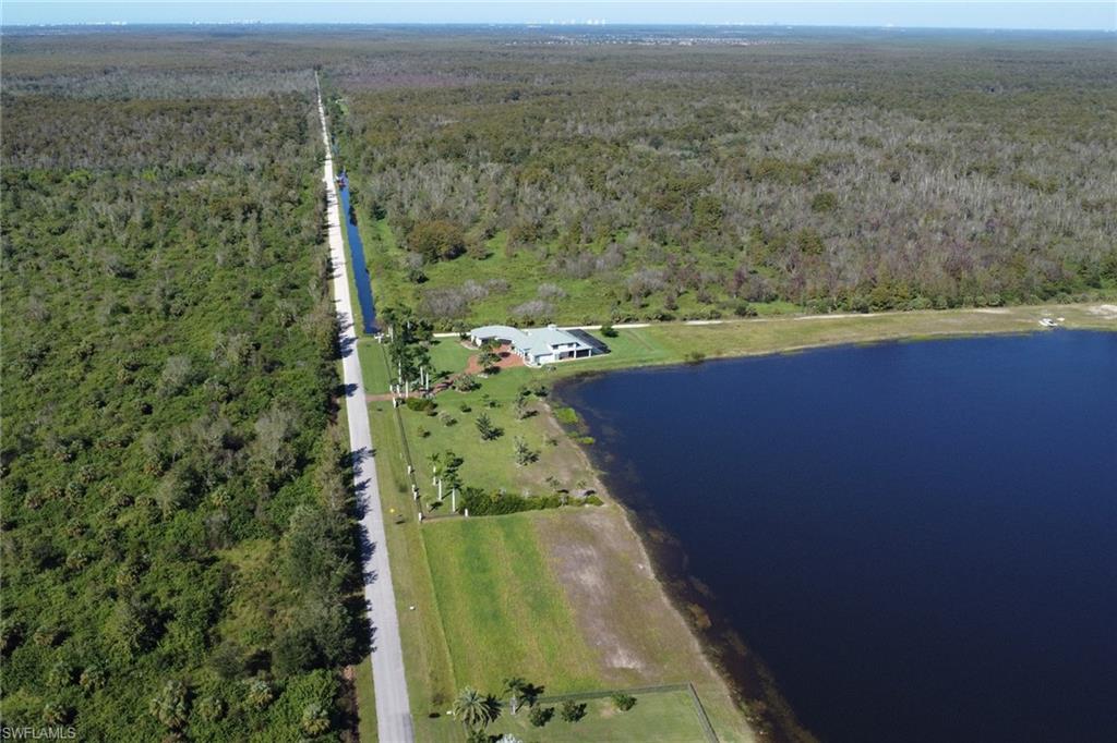 Aerial view of property and surrounding area featuring a forest