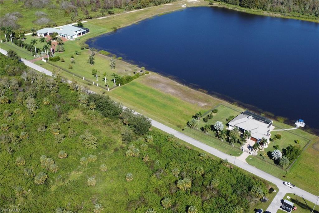 Aerial overview of property's location featuring a nearby body of water and a heavily wooded area